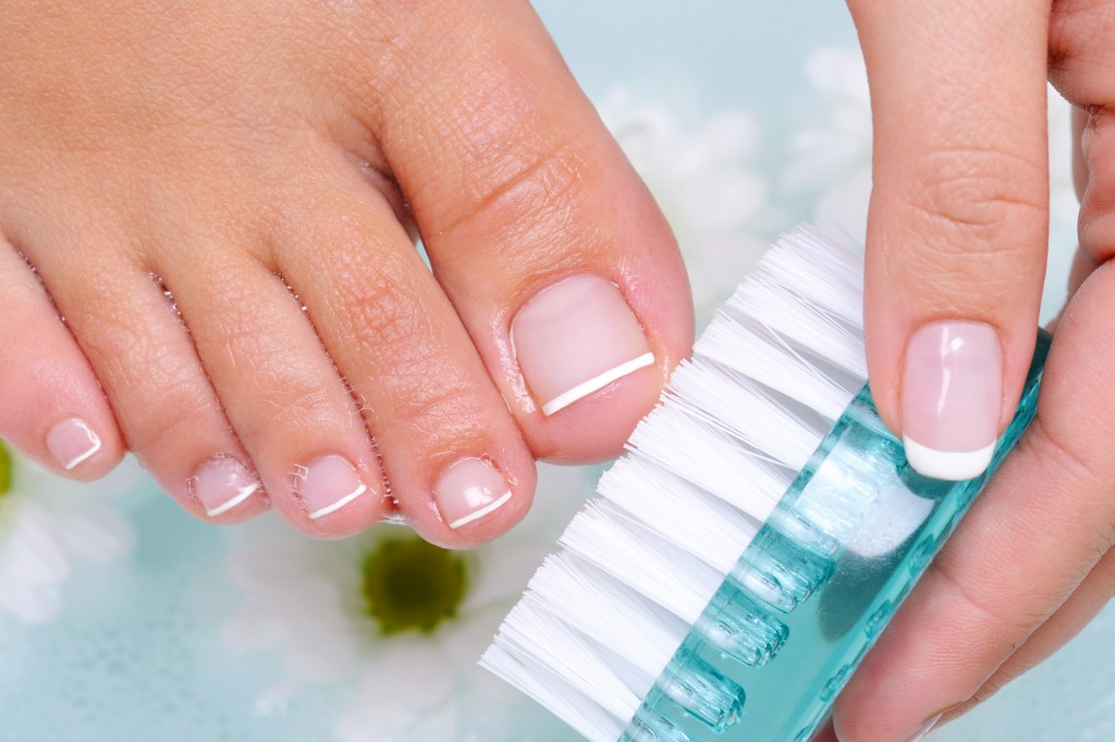 woman washes and cleans the toenails